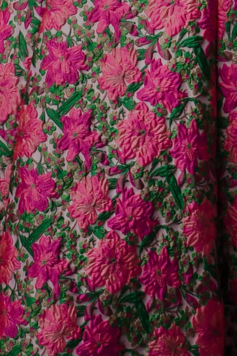 Close up of the kinjal pink floral sherwani fabric. Close up of pink flowers with green accents 